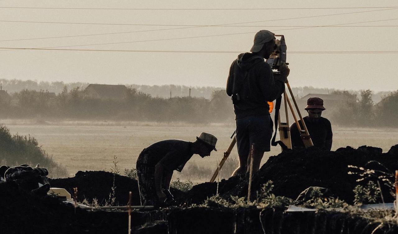 A team of topographic land surveyors carrying out a survey