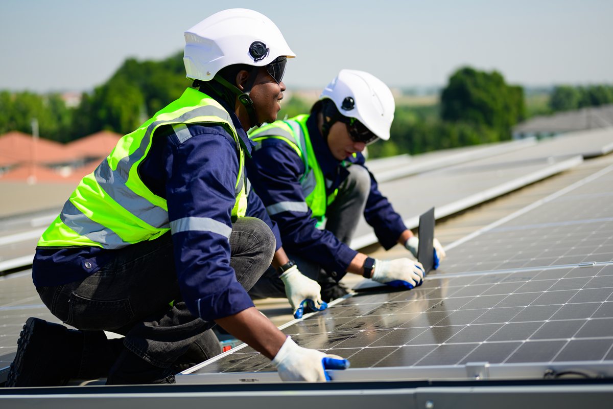 Engineer and technician using laptop checking and operating solar panels system on rooftop of solar cell farm power plant, Renewable energy source for electricity and power, Solar installation